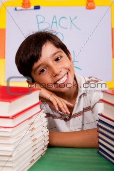 Young boy with stack of books