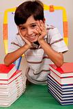 Cute young boy resting on books