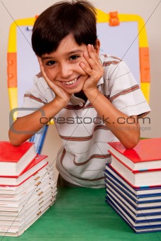 Cute young boy resting on books