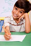 Portrait of cheerful boy writing notes