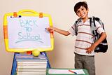 Smiling school boy pointing at white board 