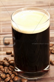 espresso in a glass with coffee beans