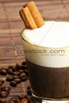 espresso in a short glass with milk froth and cinnamon inside