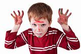 Child simulating threat, with both hands painted red and raised