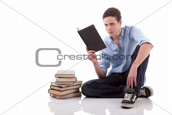 cute boy reading a book on the floor, isolated on white, studio shot