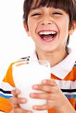 Smiling young boy holding a glass of milk 