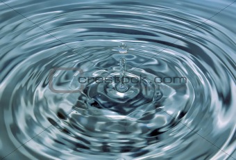 Drop falls in blue water