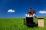 Businesswoman at a Desk In Green Field