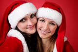Two girl friends in christmass costumes on white.