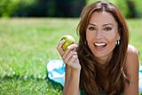 Beautiful Woman Outside Eating An Apple and Smiling