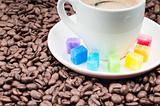 Multicolored slabs of sugar and cup of coffee