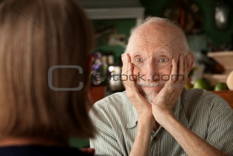 Senior couple at home focusing on man