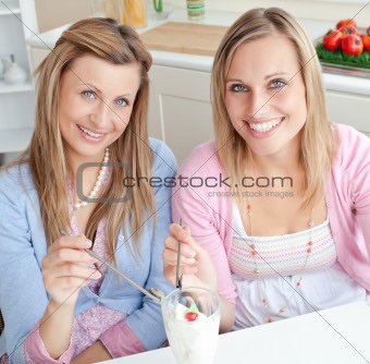 Cheerful friends eating an ice cream and smiling at the camera i