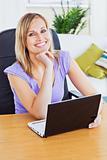 bright woman using laptop sitting in the living-room smiling at 
