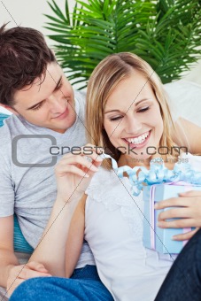 Couple lying on the sofa with a present 