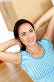 Bright hispanic woman relaxing at the middle of boxes on the flo