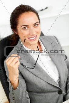 Joyful hispanic businesswoman holding glasses and smiling at the