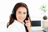 Pretty hispanic businesswoman with headset sitting at her desk