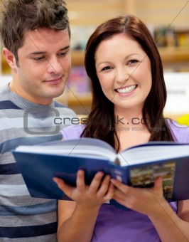 Bright couple of students reading a book