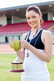 Joyful female athlete holding a trophy