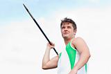 Handsome male throwing a javelin outdoors