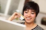 Smiling Multiethnic Woman Holding Credit Card While Using Laptop.