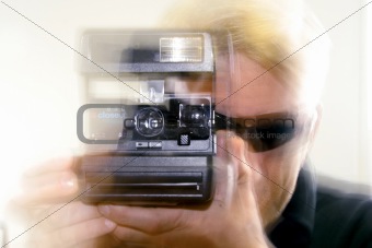 Weird looking guy shooting a Polaroid