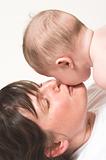 mother kissing baby on cheek