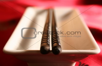 Chopsticks on a bowl in a formal dinner setting