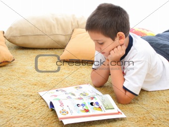 Boy reading a book on the floor