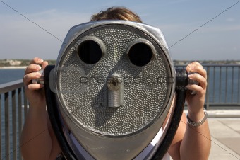 Woman looking through a coin operated binoculars