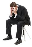 Depressed businessman sitting face in hands