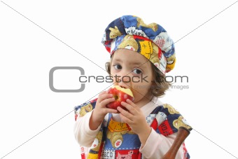 Little girl eating an apple dressed as a chef