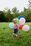 girl with balloon runs on lawn