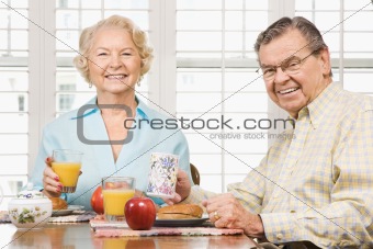 Mature couple eating breakfast.