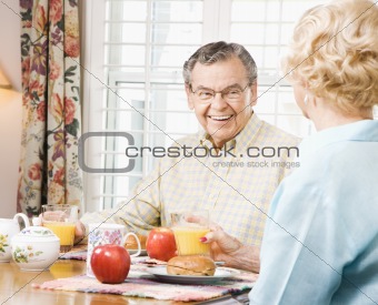 Mature couple eating breakfast.
