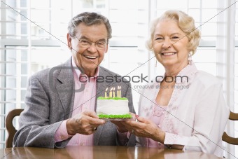 Mature couple with cake.