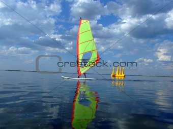 Windsurfer and its reflection in water of a gulf 