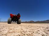 ATV Adventure on dry lake bed against clear blue sky