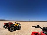 ATV adventure on dry lake bed against clear blue skies
