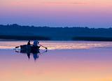 Two men in a boat on evening lake