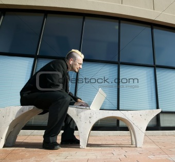 Punk Businessman on Laptop Computer Listening to Personal Music 
