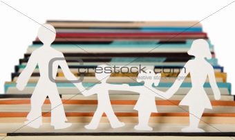 Family figures made from paper with books background