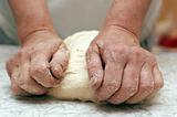 Hands of woman baker kneading dough