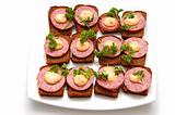 Many small open sandwichs on white plate