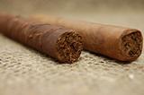 Two cuban cigars on hessian canvas
