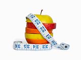 Slices of apples and orange as one fruit and a measuring tape