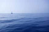 Blue sea with sailboat sailing the ocean surface summer