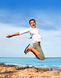 boy teenager high fly jump on beach blue sky