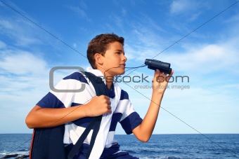 boy teenager binoculars explorer in blue beach